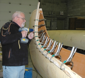 Patiently applying the curved end sections to the North canoe.