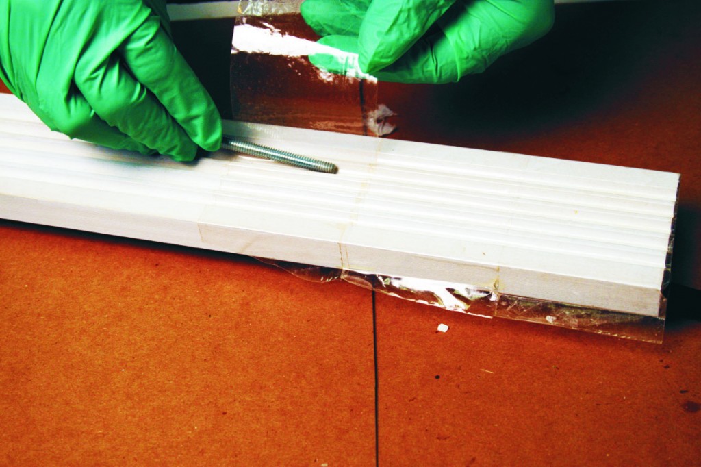 We use plastic packaging tape as a mold release for repairing damaged wood trim.