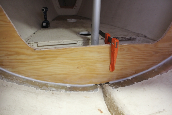Hog Tide's new bulkhead clamped to the tabbing from the old bulkhead to hold it in place, and the new fillet applied.