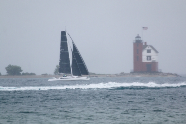 Heavy winds and rain as Adagio passes Round Island Lighthouse to finish the race first in the multihull division of the 2016 Bayview Mackinac Race.