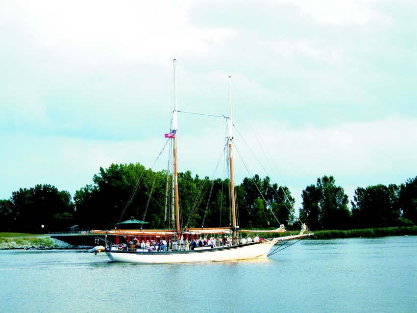 Appledore IV makes her way upriver after a cruise on the Saginaw Bay with her restored topmasts in place.