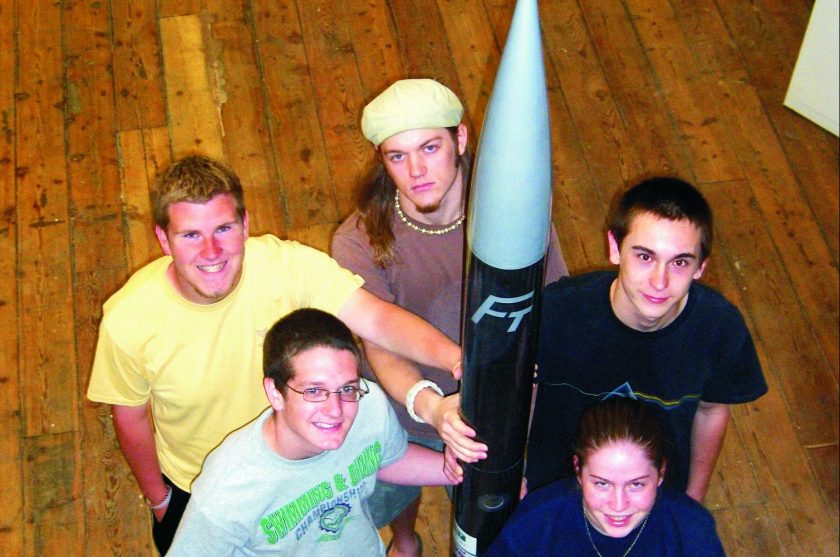 The Flying Tigers rocket team with their finished 8' 4" rocket. From bottom left, clockwise: James Roesner, Richard Lester, Brad Parker, Kyle Smith and Brett Cockerill.