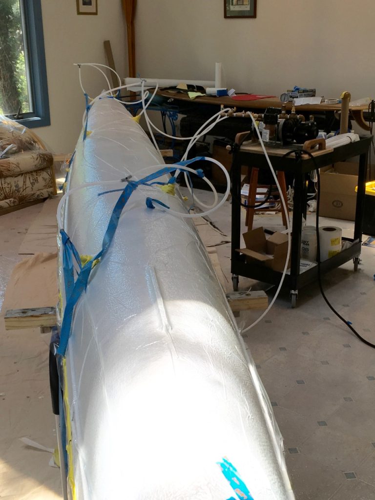  The epoxy was followed by the application of release fabric, breather fabric, and the vacuum bag film. Sealant tape along the edges made the vacuum bag film air tight and appropriate hose connections were made, before applying the vacuum pressure at (-)15mm Hg. - Epoxyworks # 60, Spring 2025.